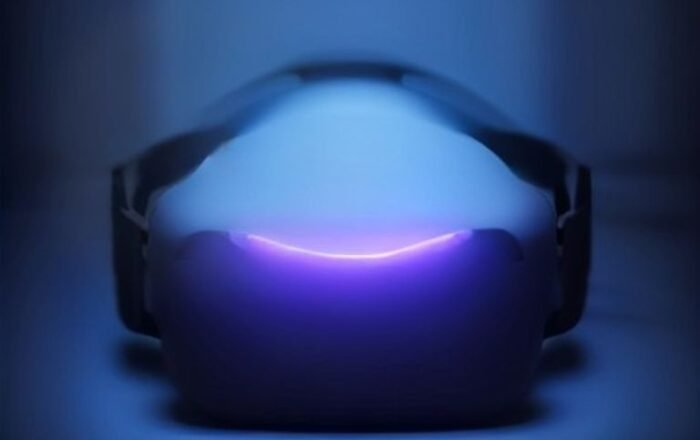 A modern virtual reality headset resting on a dark surface with glowing ambient light.