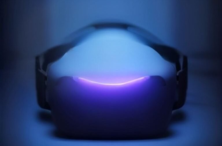 A modern virtual reality headset resting on a dark surface with glowing ambient light.